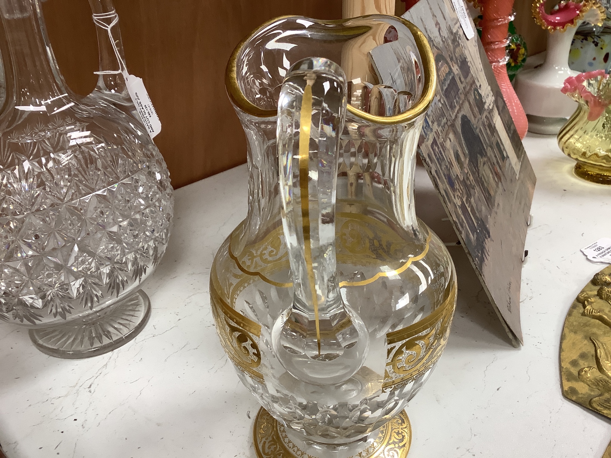 A Baccarat gilt and cut glass jug and a strawberry cut glass decanter and stopper, tallest 38 cm